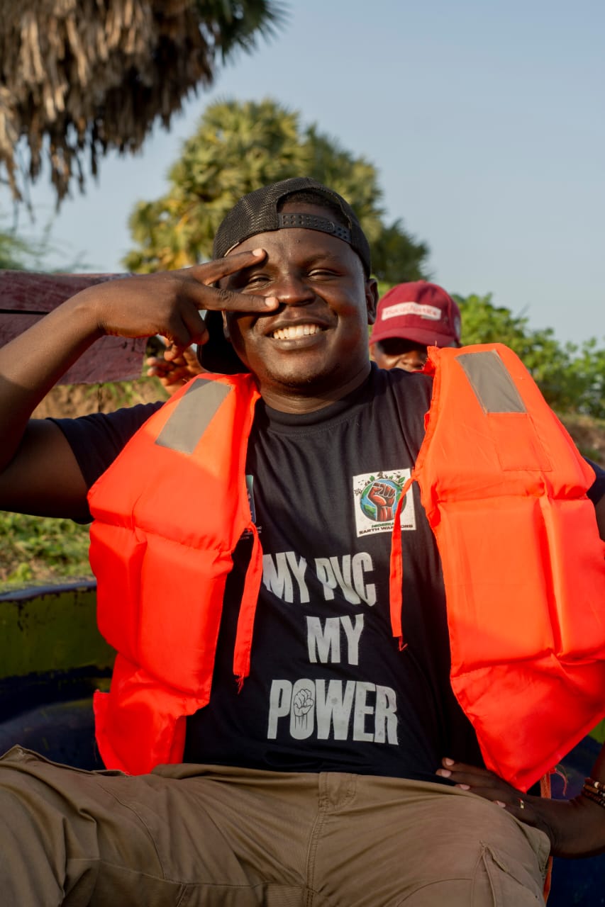 Field team in boat wearing Register, Decide, Vote, Not Fight shirt